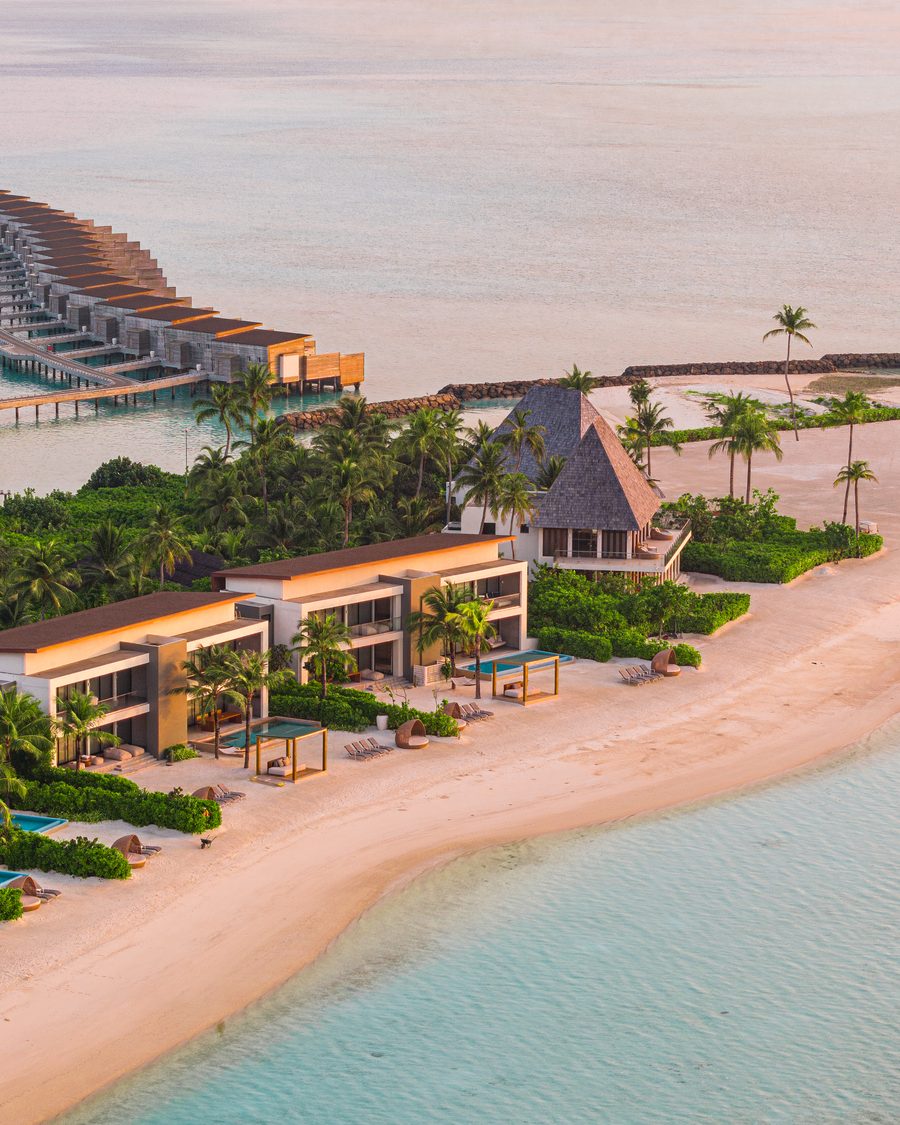 Overwater villas at a Maldives resort at sunset.